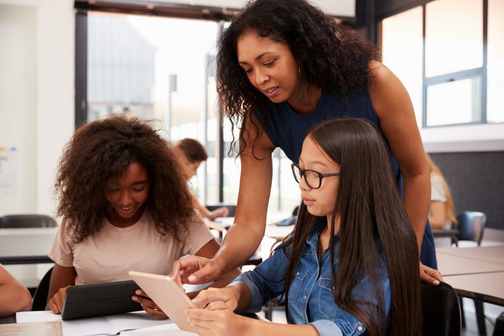 teacher helping two students with their studies