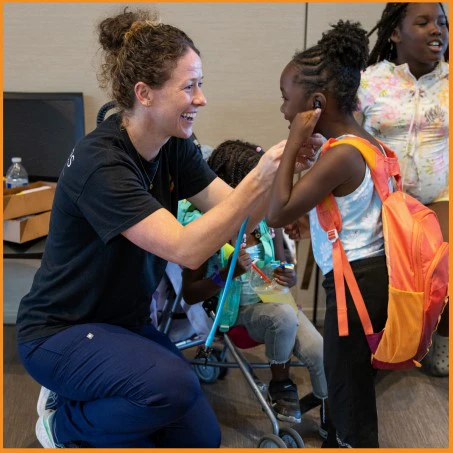 female doctor with child wearing backpack